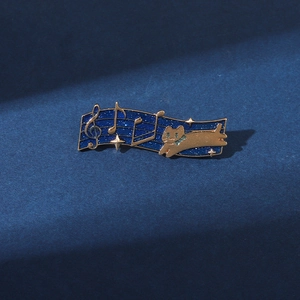 Detail of music cat enamel pin featuring starry sky motif and golden musical notes