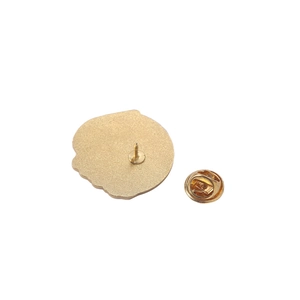Vue détaillée du dos d'un pin's en métal doré montrant l'aiguille et le fermoir papillon