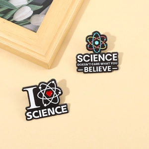 Cartoon science enamel pins featuring atomic models and inspirational scientific text
