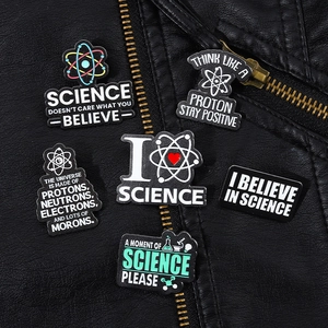 Detailed view of six science enamel pins pinned on a black leather jacket with metallic zippers