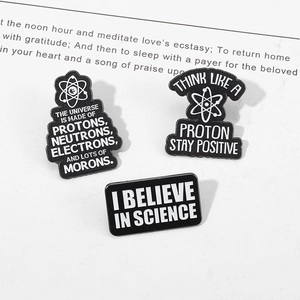 Set of three black and white enamel science pins with atomic models and geeky motifs