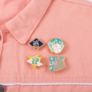 Gros plan de quatre pin's émaillés Demon Slayer sur une veste en jean rose, détails nets