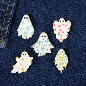 5-piece Halloween ghost enamel pin set with maple leaf and heart motifs on denim