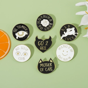 Macro shot of colorful enamel pins with cat, rabbit, and heart designs on a green base