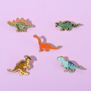 Lot de cinq épingles émaillées dinosaures avec bordure en métal doré sur fond violet