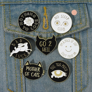 Detail of seven unique enamel badges with pins on a blue denim jacket pocket