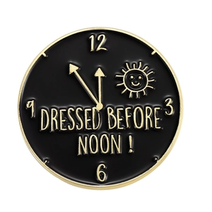 Kreative Emaille-Brosche in Schwarz-Gold mit Uhrendesign und Dressed Before Noon Text