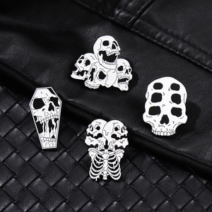 Set of four punk style skull enamel pins in black and white finish for clothing decor
