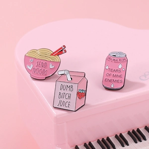 Set di tre spillette in smalto rosa con ciotola di ramen e succo di fragola su piano