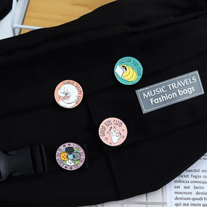 Set of four colorful cartoon cat enamel pins on a black canvas bag with creative slogans