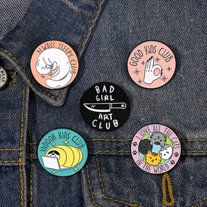 Set of 5 cartoon cat enamel pins on blue denim jacket featuring funny cat illustrations