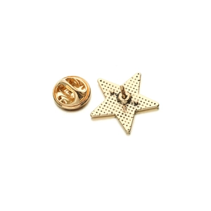 Detailed back view of a gold star-shaped brooch with non-slip texture and butterfly clasp