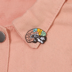 Detailed close-up of colorful human brain enamel pin on pink denim collar