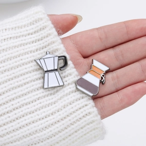 Cartoon coffee moka pot and hand drip kettle enamel brooches on a white knit sweater