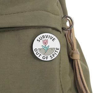 Insigne rond en émail tulipe avec texte sur un sac à dos vert au style minimaliste