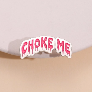 Enamel brooch pin featuring pink liquid font CHOKE ME text on white background