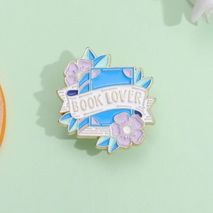 Exquisite Book Lover enamel brooch featuring blue book and purple flowers with gold trim