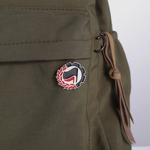 Creative geometric flag enamel pin on army green fabric backpack with detailed stitching