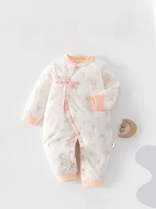 Détail de la barboteuse fleurie pour bébé avec boutons chinois et glands décoratifs