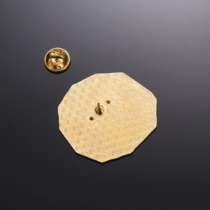Macro shot of gold metal badge back showing honeycomb texture and butterfly clutch pin