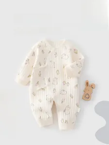 Detailed close-up of quilted cotton baby romper with floral rabbit print and tie closure