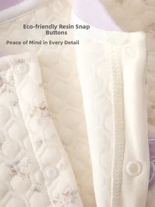 Détail d'une barboteuse pour bébé en coton matelassé à fleurs et boutons-pression en résine