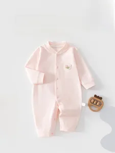 Details des rosa Baby-Stramplers aus Baumwolle mit Blumen-Patch und Druckknöpfen