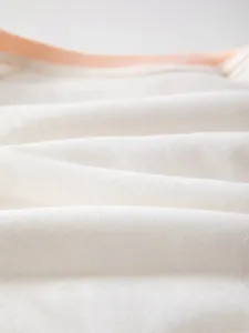 Gros plan sur la texture du coton blanc doux et respirant pour barboteuse bébé