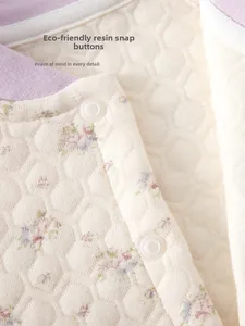 Detail of baby thermal quilted cotton outfit with resin snaps and floral pattern
