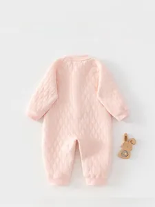 Détail d'une barboteuse matelassée rose pour bébé avec texture losange et poignets côtelés