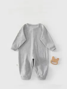 Detail of the baby long sleeve romper back featuring soft cotton fabric and wood bear toy