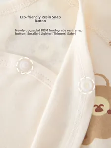 Détail macro du barboteuse bébé avec boutons-pression en résine et imprimé ours mignon