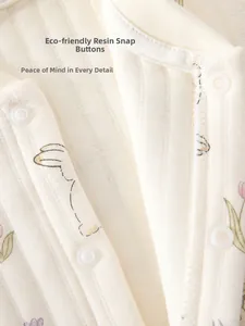 Close-up of eco-friendly resin snap buttons on cotton ribbed baby romper with floral prints