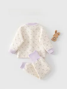 Close-up of quilted floral thermal baby pajamas with ribbed cuffs and back details