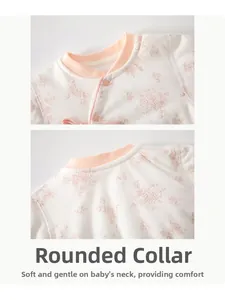 Détail de la combinaison fleurie pour bébé avec col rond bordé de rose et boutons-pression