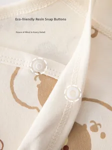 Detail view of eco-friendly resin snap buttons on cotton baby clothes with elephant print