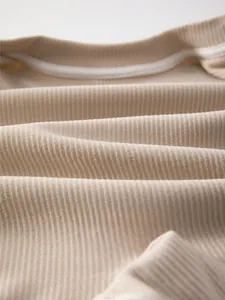Detailed close-up of soft ribbed knit cotton fabric for infant onesies in khaki