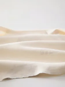 Detailed macro shot of breathable soft cotton fabric for newborn baby clothing