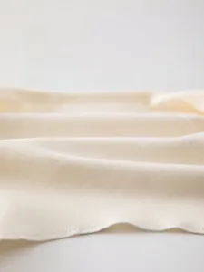Close-up of soft knitted cotton fabric texture for newborn baby undershirt