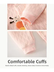 Détail d'une barboteuse matelassée rose pour bébé avec poignets élastiques et broderie chenille