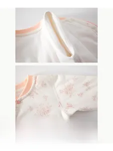 Détail d'un body floral pour bébé montrant les coutures plates et les boutons-pression