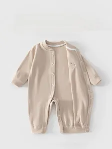 Detailed view of beige ribbed knit baby romper with convenient full-length snap buttons