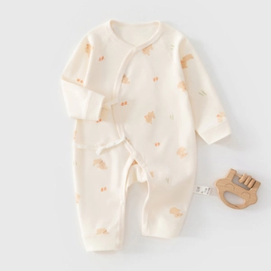 Détail d'une grenouillère bébé en coton avec imprimé ours et jouet de dentition en bois