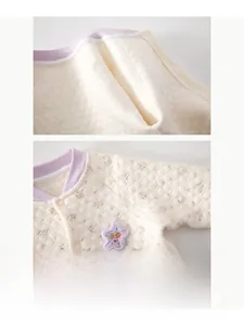 Détail d'une barboteuse matelassée en coton pour bébé avec imprimé floral et pressions