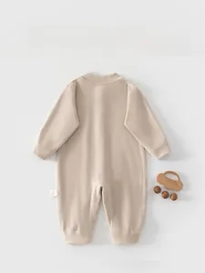 Detailed back view of baby romper featuring waffle knit texture in apricot pink color