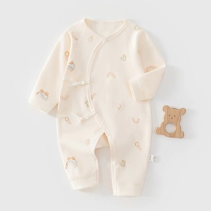 Détail d'une grenouillère bébé en coton montrant l'étiquette 100% coton et motifs