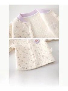 Macro shot of quilted baby thermal top with floral prints and resin snap buttons