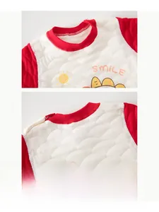 Close-up of quilted fabric and button shoulder detail on a red baby sweatshirt