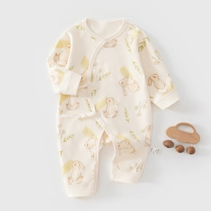 Détail d'un body bébé en coton avec imprimé lapin et fermeture croisée à nouer