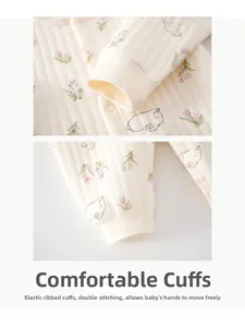 Close-up of ribbed cuffs and floral rabbit print on quilted newborn baby cotton romper